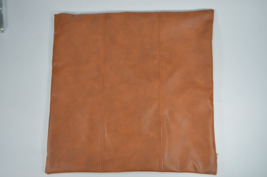 Brown faux leather cushion covers styled on a bed